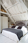 Graue Decke auf einem Doppelbett in einem weiß getünchten Bauernhaus, Frankreich