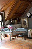 Large velvet cushion on vintage metal chair under wooden ceiling in French farmhouse
