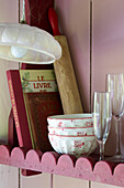 Vintage recipe books and kitchenware on shelf in Brittany cottage, France