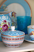Patterned sugar bowl with chinaware on shelf in London family home, England, UK