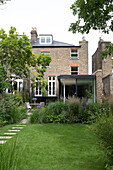 Hinterer Garten und Backsteinfassade eines Hauses in Oxfordshire England UK