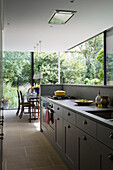 Grey fitted open plan kitchen room with dining room extension in Oxfordshire home England UK