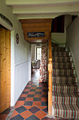 Striped staircase carpet with terracotta tiled hallway in Ceredigion cottage Wales UK