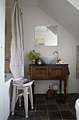 Spiegel über hölzernem Waschtisch im Badezimmer eines Cottage in Presteigne, Wales UK