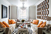 Mirror collection with yellow cushions on sofas in living room of London home, England, UK