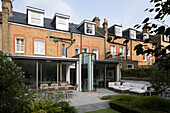 Dachgaube in Backsteinfassade eines Reihenhauses in Sussex mit Gartenerweiterung, England, Vereinigtes Königreich