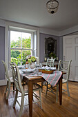 Striped tablecloth on dining table with wooden floorboards in UK home