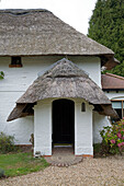 Whitewashed porch of detached Sussex thatched cottage   England   UK
