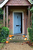 Pumpkins on doorstep in brick porchway of London home,  England,  UK