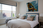 Double bed with matching lamps and artwork in contemporary London bedroom   UK