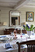 Silver framed mirror in dining room with embroidered tablecloth in UK farmhouse
