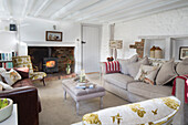 Befeuerter Holzofen in weiß getünchtem Wohnzimmer mit niedriger bemalter Decke, Londoner Haus, England, UK