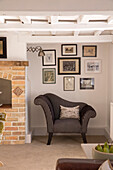 Black and white upholstered armchair with artwork collection in alcove of London home,  England,  UK