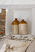 Vintage storage jars on recessed shelving with exposed brickwork in London home,  England,  UK