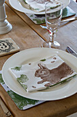 Rabbit napkin on place setting on wooden dining table in London home,  England,  UK