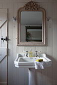 Mirror above pedestal basin in bathroom detail of London home,  England,  UK