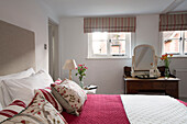 Striped roman blinds at window with dressing table and embroidered pillows in London bedroom,  England,  UK