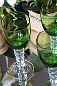 Green glassware on mirrored tabletop in London home,  England,  UK