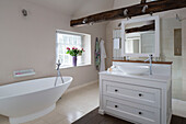 Freistehende Badewanne und Waschbecken in einem Haus mit Balken in Surrey, England, UK