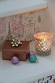 Christmas present and baubles with lit candle in Laughton home  Sheffield  UK