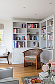 Wooden armchair and bookcase in corner of London living room   England   UK