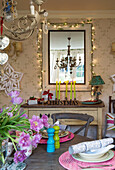 Fairylights on mirror above sideboard in Sussex dining room  England  UK