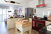 Offene Küche mit rotem Herd und Weihnachtskuchen in einem Haus in Surrey, England UK