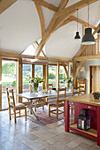 Offene Küche mit Holzbalkendecke und Tisch in einem Bauernhaus in Sussex England UK