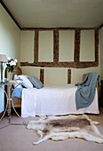 Single bed with fur rug in timber framed Sussex farmhouse   England   UK