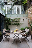Table and chairs in private courtyard of London townhouse   England   UK