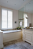 Mirrored cream bathroom with shuttered windows in London townhouse   England   UK