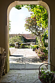 View through stone doorway to garden of Warminster home  Wiltshire  England  UK