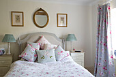 Lampenpaar am Bett mit geblümten Stoffen im Landhaus in Warminster, Wiltshire, England, Vereinigtes Königreich