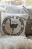 Ostrich print with French text on cushion in East Dean farmhouse  West Sussex  UK