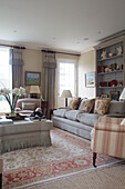 Hellgraues Sofa und Sessel mit Bücherregal im Wohnzimmer in Pewsey, Wiltshire, England, Vereinigtes Königreich