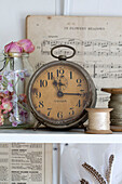 Vintage-Uhr und Notenblätter mit Klöppeln auf einem Regal in einem Haus in Norfolk England UK