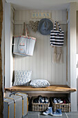 Bags and shoes with suitcase at bench seat in Wokingham cottage hallway Berkshire UK