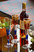 Weingläser und Flasche auf Glastisch in Londoner Stadthaus, UK