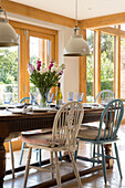Verschiedene Stühle mit Sitzkissen am Esstisch in einem Haus in Surrey, England UK