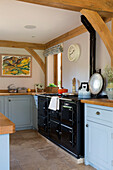 Hellblaue Einbauküche mit schwarzem Backofen in einem Haus in Surrey, England UK