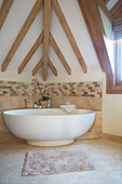 Freestanding bath in corner of timber framed Surrey bathroom England UK