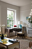 Desk and chair at sunlit Georgian window in London townhouse England UK