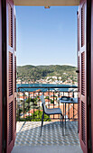 View through shuttered doorway to chair on balcony of 18th century Ithaca townhouse Greece