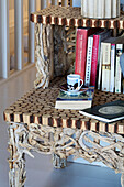 Tasse und Untertasse mit Büchern auf hölzernem Beistellschrank in einem Stadthaus in Ithaka, Griechenland, 18