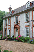 Stein- und Ziegelfassade eines freistehenden Landhauses in Sussex England UK