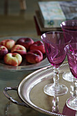 Pink wineglasses and apples on pewter trays in Sussex country house England UK