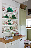 Verschiedene Teetassen und Teller auf einer Küchenkommode in der Küche eines Hauses in Dorset England UK