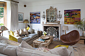 brown leather armchair with wooden coffee table and sofas with yellow cushions in Arundel home West Sussex England UK
