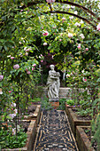 Female statue viewed through pergola in parterre garden Arundel West Sussex England UK