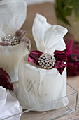 Diamante brooch with velvet ribbon on fabric wrapped candle in West Sussex home England UK